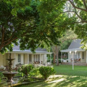Rosenhof Boutique Hotel: a white house with trees in the yard