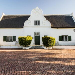 Rotterdam Estates Guest Farm and Wedding Venue: a white house with a black roof and a brick driveway