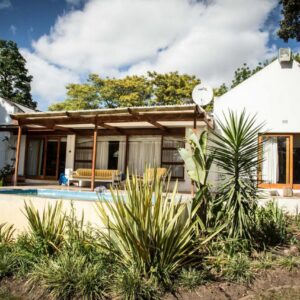 Rouana Guest Farm: a house with a pool in front of it