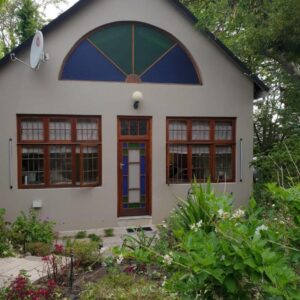 Rozenhof Guest Cottages: a small white house with a large window