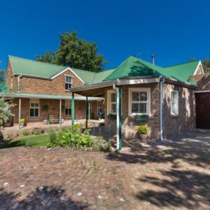 Rustic Manor Guest House: a brick house with a green roof and a garage