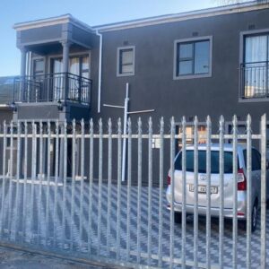 Sabbath Lodge VIP: a white fence in front of a house with a car