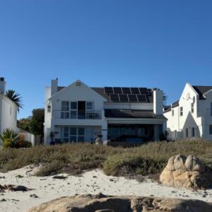 SableChateau Beachfront Guesthouse: a house with solar panels on the beach