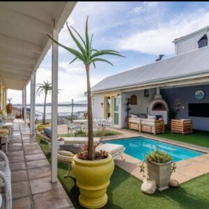 Salty Bay Guesthouse: a house with a pool and a palm tree in a yard