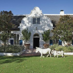 San Gabriel Homestead: two lambs walking in front of a white house