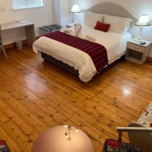 Savoy Hotel Beaufort-West: a bedroom with a bed with a teddy bear on it