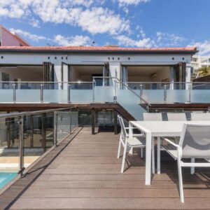 Sea Breeze Guesthouse: a balcony with a table and chairs on a house