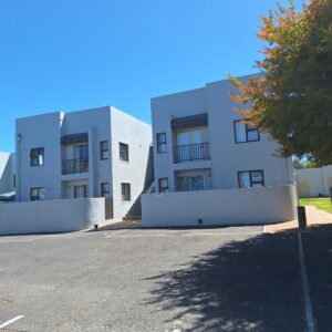 Serengeti Heide Self Catering Flats: an empty parking lot in front of a white building