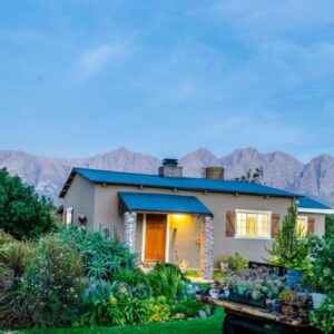 Seven Oaks Vineyard Cottages: a house with mountains in the background