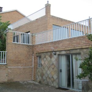 Shirleys Place: a brick house with a balcony on top of it