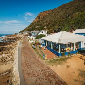 Silver Spray Beach Accommodation: a blue house on the beach next to the ocean