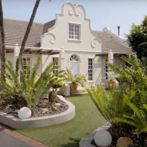 Simply The Choice Manor: a white house with palm trees in front of it