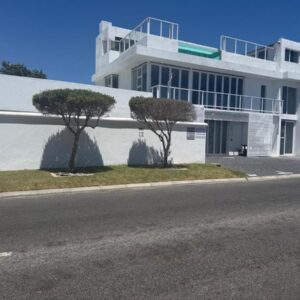 Skypool Guesthouse: a white building with two trees in front of it