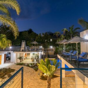 Somervreug Guesthouse: an outdoor deck with chairs and an umbrella on a house