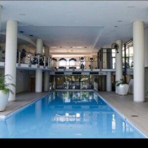 SS Luxury Apartments: a large swimming pool with potted plants in a building