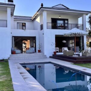 Stables on Kloof Country House: a white house with a swimming pool in front of it