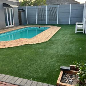 StayLovia: a backyard with a swimming pool and a lawn
