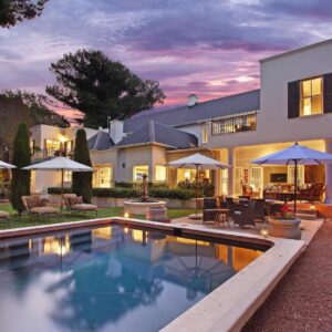 Stellenbosch Manor: a house with a swimming pool in front of it