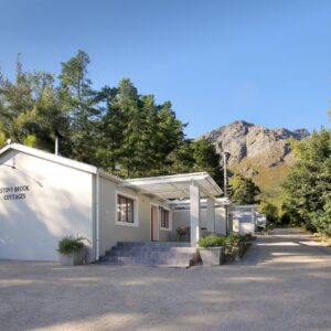 Stony Brook Cottages: a white building with trees and mountains in the background