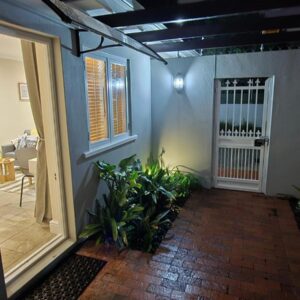 Striped Horse Guest House - Kenilworth Upper: a hallway of a house with a door and plants