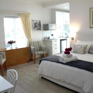 Summer Place, Constantia, Cape Town: a bedroom with a bed and a table and a kitchen