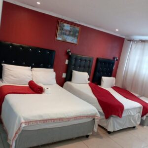 Sunshine Guest House: two beds in a hotel room with red walls