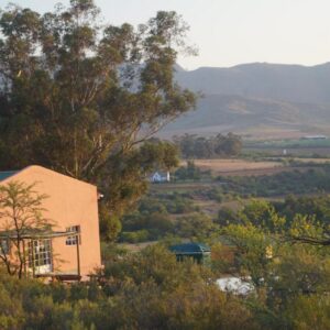 Swartberg Backpackers Booked for you Only No sharing: a house on the side of a hill with trees