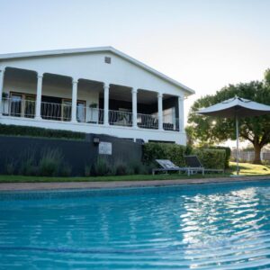 Swartberg Country Manor: a house with a swimming pool in front of a house