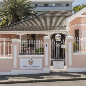 Sweet Orange Guest House: a pink house with a gate in front of it