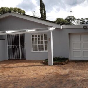 Swellendam Overnight Accommodation: a house with a white garage with a driveway