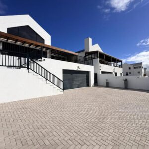 Swordfish Retreat: a white building with a garage and a sky