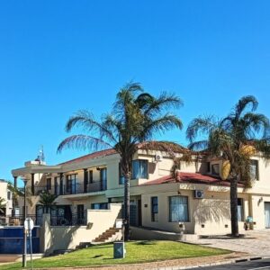 Table Mountain Guesthouse: a building with palm trees in front of it