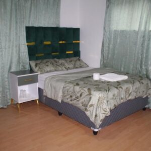 Tatami Guesthouse: a small bed in a room with curtains