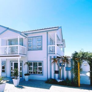 The Bucket List Guest House: a white house with palm trees in front of it