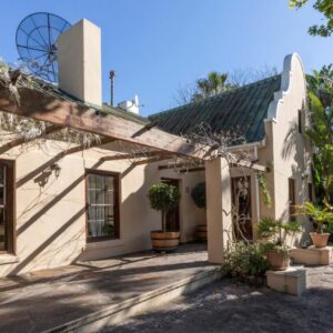 The Country Guesthouse: an exterior view of a white house with plants