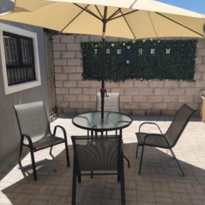 The Gem Guest House & Spa: a table and two chairs and an umbrella on a patio