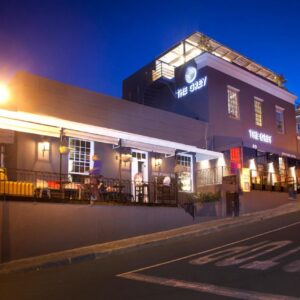 The Grey Hotel: a building with a restaurant on a street at night
