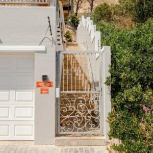 The Grosvenor Guest House & Self Catering: a white fence with a gate next to a house