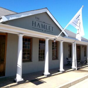 The Hamlet Country Lodge: a building with two flags in front of it