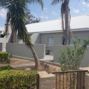 The Hermon Hotel: a house with two palm trees and a fence