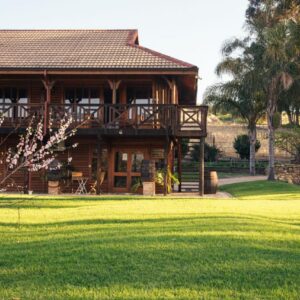The Log Collective: a log cabin with a lawn in front of it