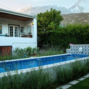 The Montagu Coach House: a swimming pool in front of a house