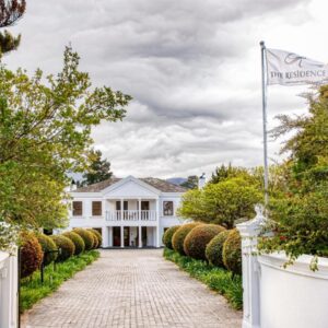 The Residence Boutique Hotel: a white house with a white fence and a driveway