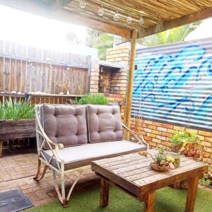 The Retreat: a swinging chair on a patio with a table