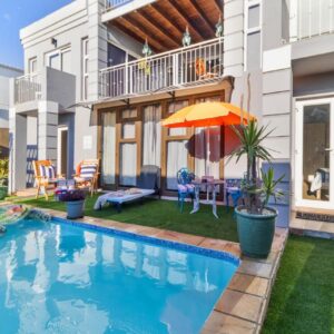 The Sandcastle Guesthouse - Melkbosstrand: a swimming pool in the backyard of a house