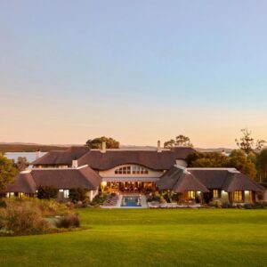 The Thatch House Boutique Hotel, Hermanus: an aerial view of a house with a green lawn