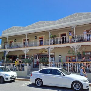 The Vic 1906 Self Catering Units: two white cars parked in a parking lot in front of a building