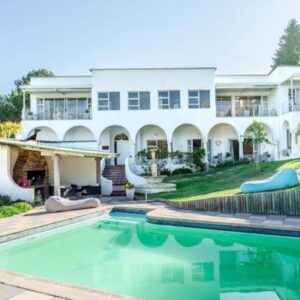 The Views Guesthouse: a large house with a swimming pool in front of it