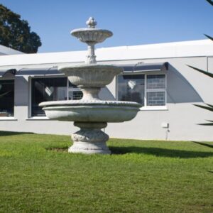 The Vintage Crane Guest House: a fountain in the grass in front of a building
