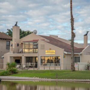 The Waterfront Guest House: a house next to a river with a boat in it
